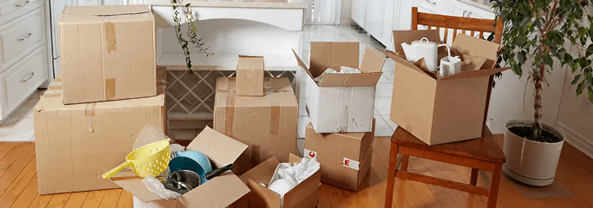 Packed moving boxes and household items in a kitchen before move-out or move-in cleaning, West Palm Beach, FL.